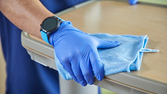 Disinfecting a patient room with a blue Ecolab wipe