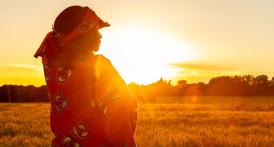 A young African woman looking into the sunny horizon