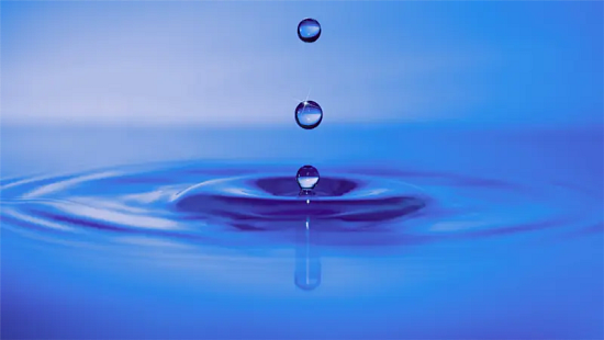 Water droplets falling into a blue water surface, creating ripples that symbolize the growing value of water as a critical business asset.